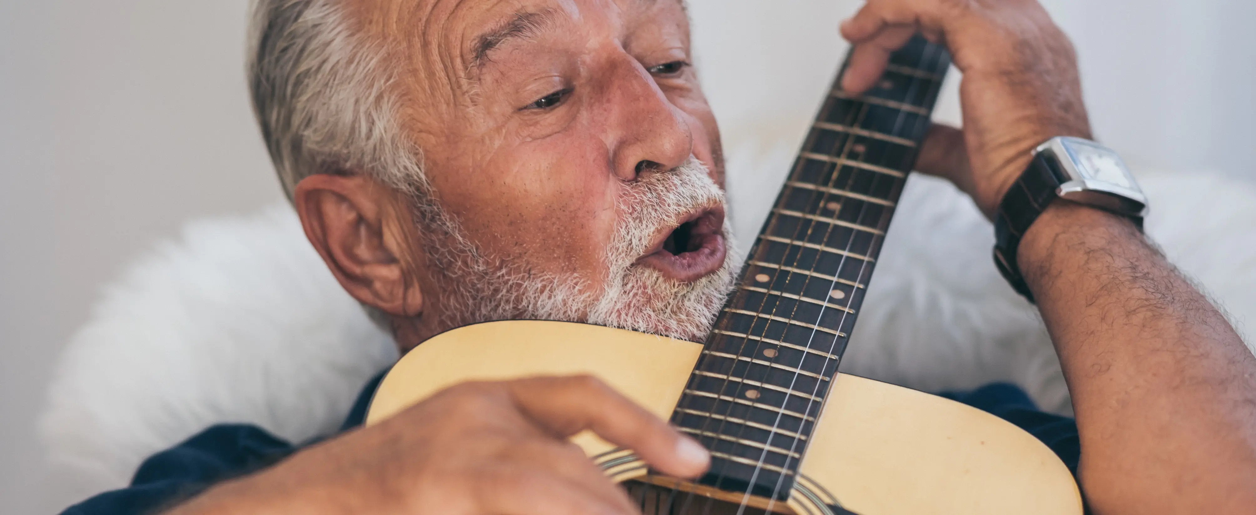 Senior spielt auf seiner Gitarre.